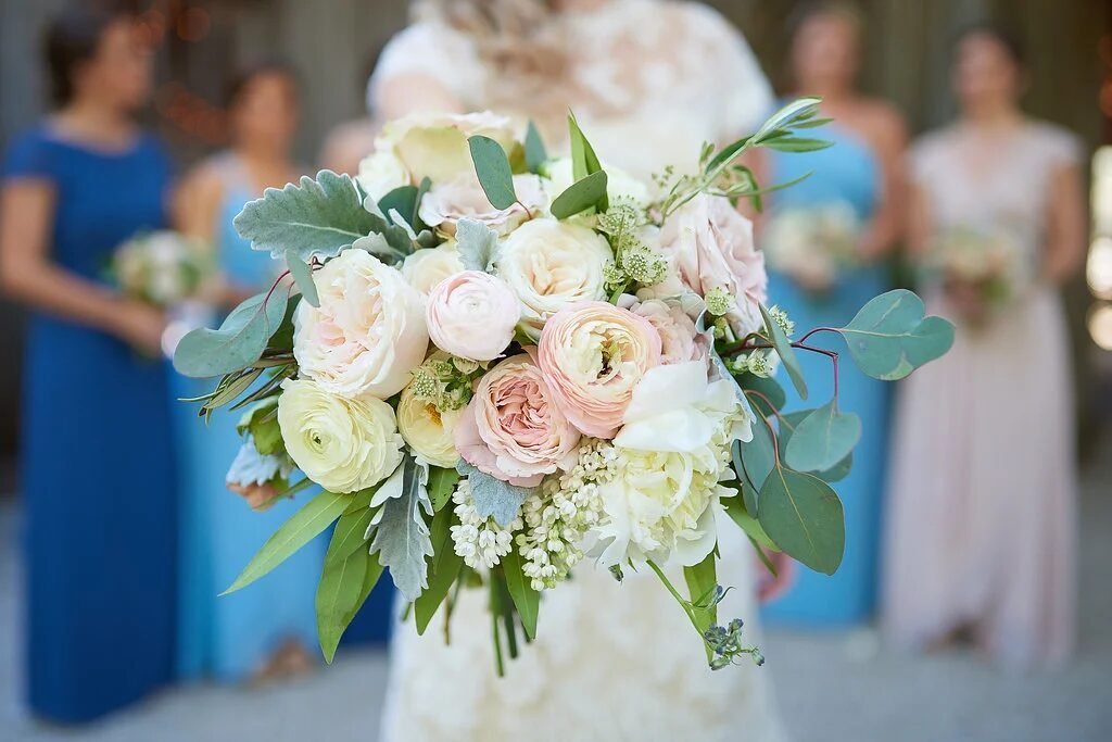 Candlelit barn reception with draped fairy lights, greenery garland runner and cross-back chairs